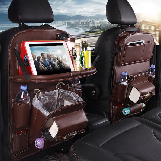 Brown leather RoadTrip car backseat organizer with tablet holder, water bottle pockets, and built-in trash bag, mounted on car seat