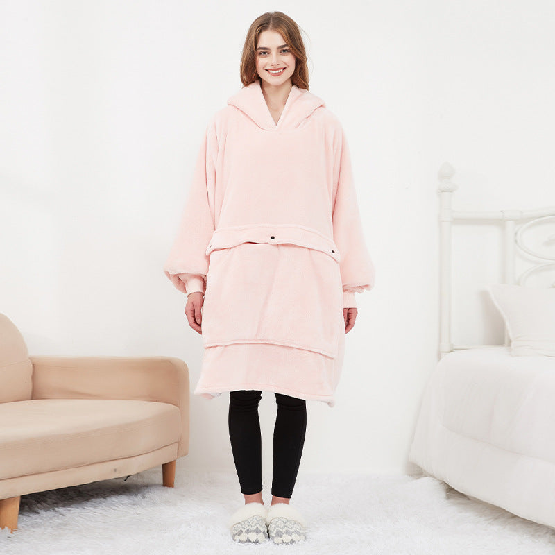 Woman wearing pink CozyGlow wearable heated hoodie blanket full-length front view in white bedroom
