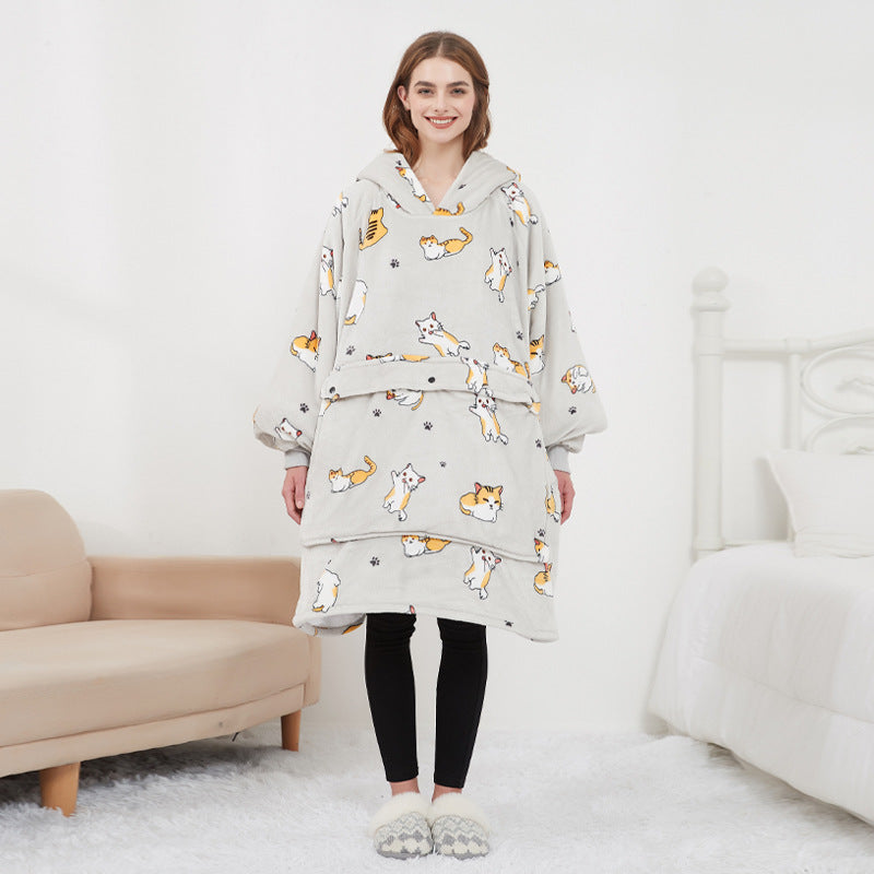 Woman wearing cream corgi and cat print CozyGlow wearable heated hoodie blanket in white bedroom