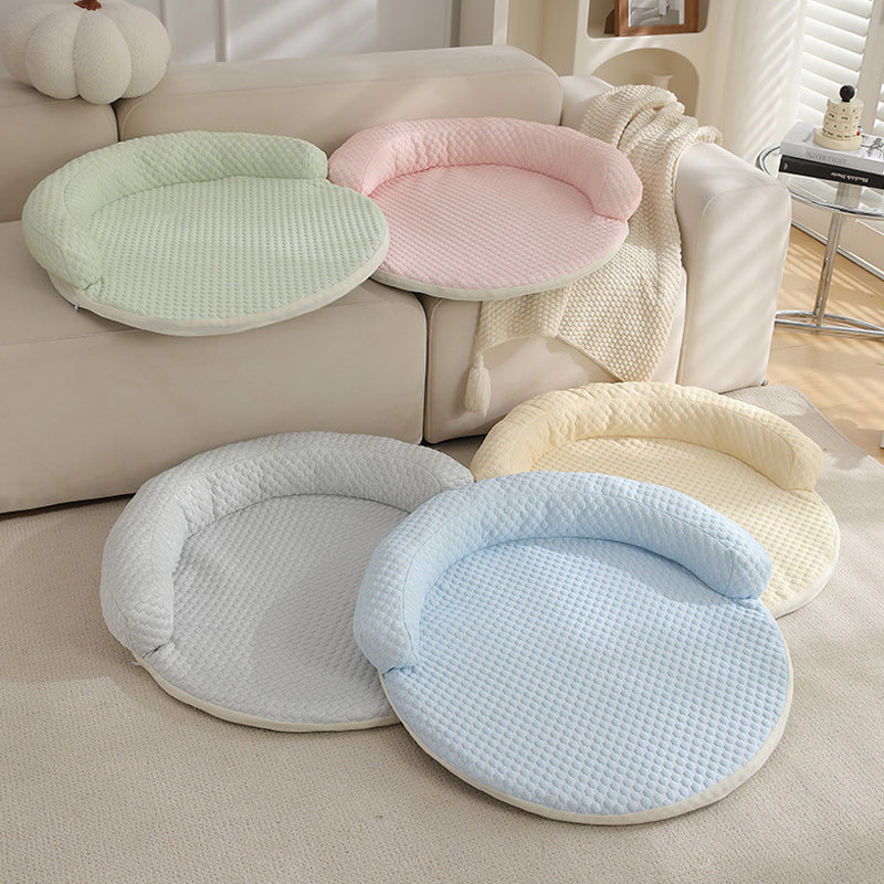 CoolPaws pet cooling mats in green, pink, cream, gray, and blue on a couch